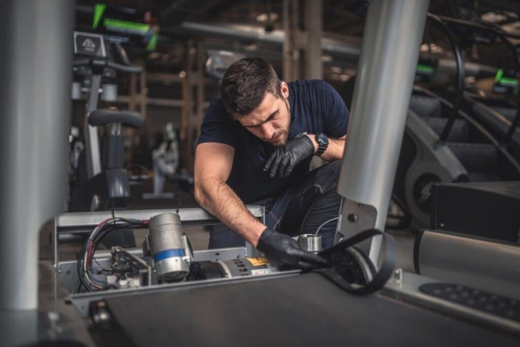 Tecnico Pro-Fitness al lavoro su tapis roulant